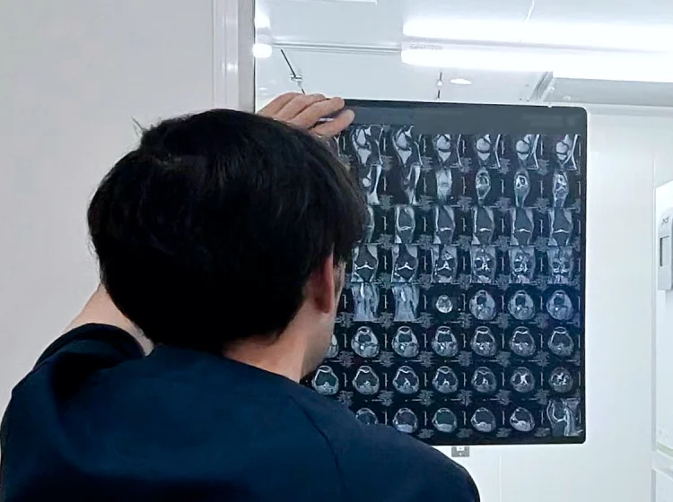 医師が患者に膝関節のMRI画像を説明する診察の様子 銀座YRクリニック